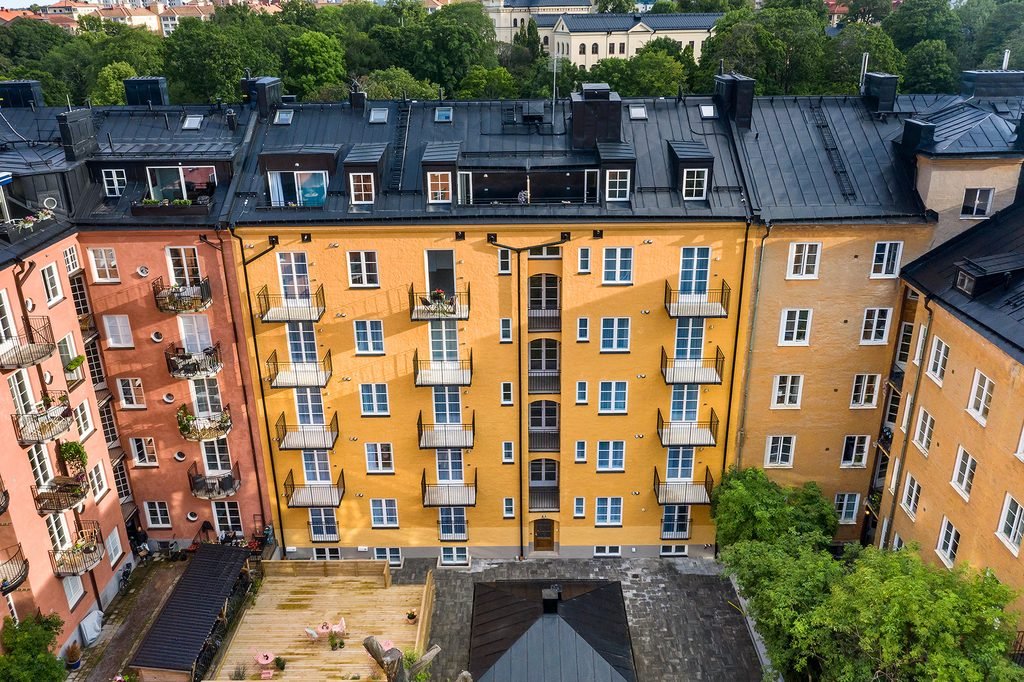Innergården sedd ovanifrån, omgiven av husets gula och röda fasader.